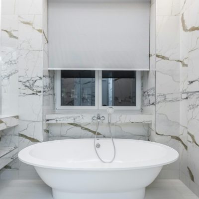 Modern bathroom featuring a luxurious marble design and a sleek freestanding bathtub.